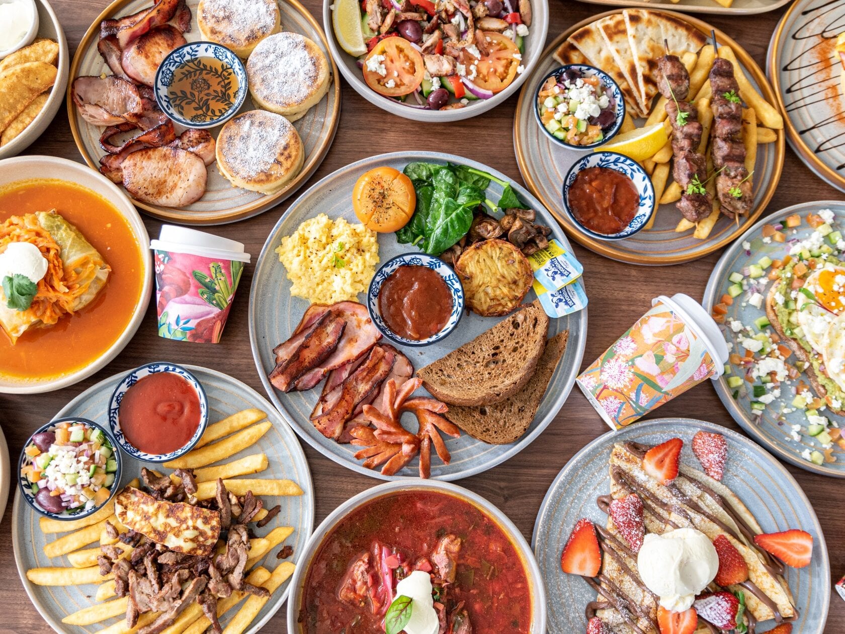 A Shamora spread: crepes, eggs, grilled skewers, dumplings and house sauces on a wooden table